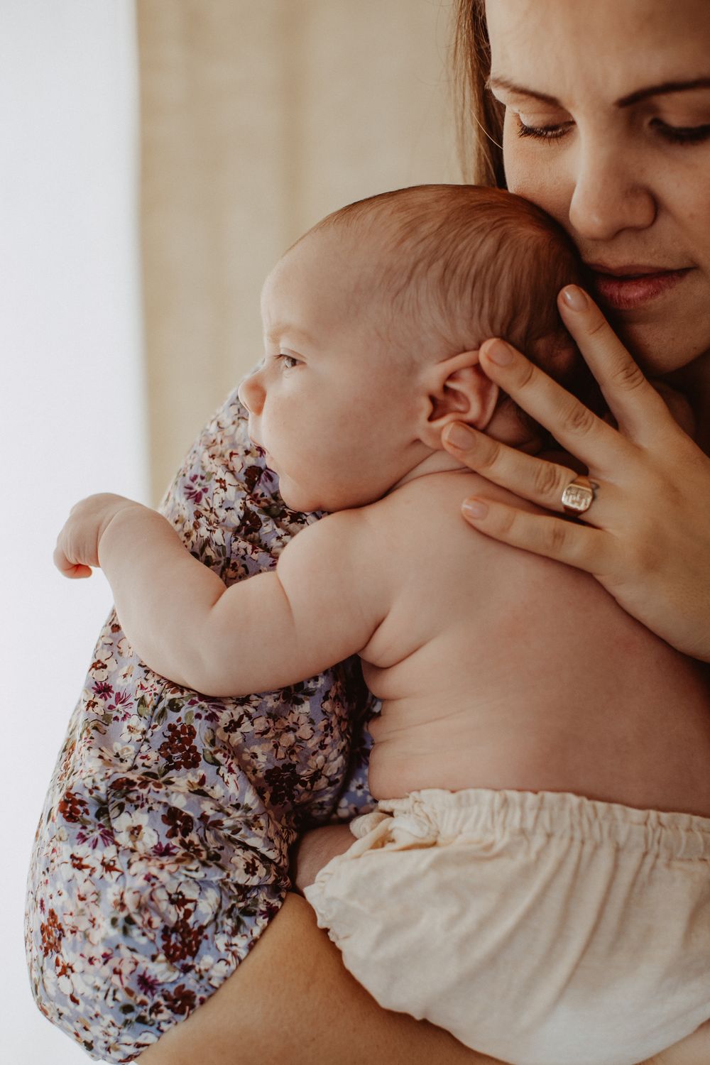 Tender moments captured in warm tones with floral baby clothing.