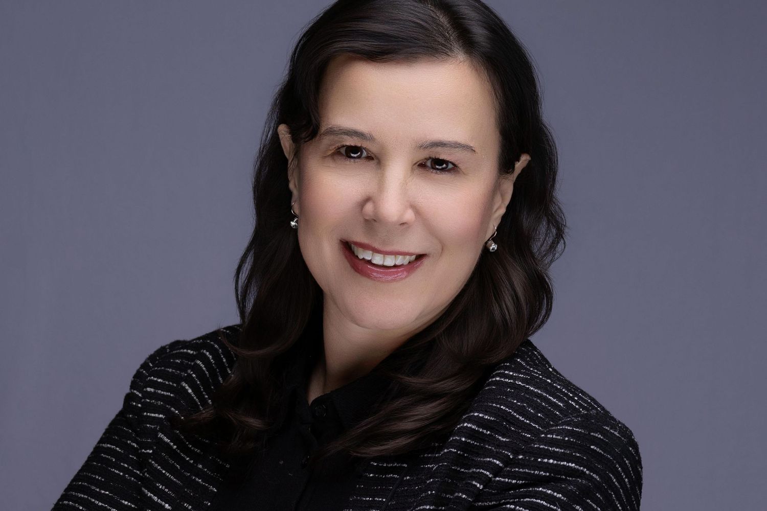 Studio-lit portrait of smiling business executive