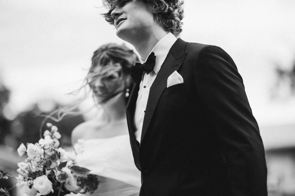 Black and white portrait of a formal wedding moment with delicate floral bouquet.