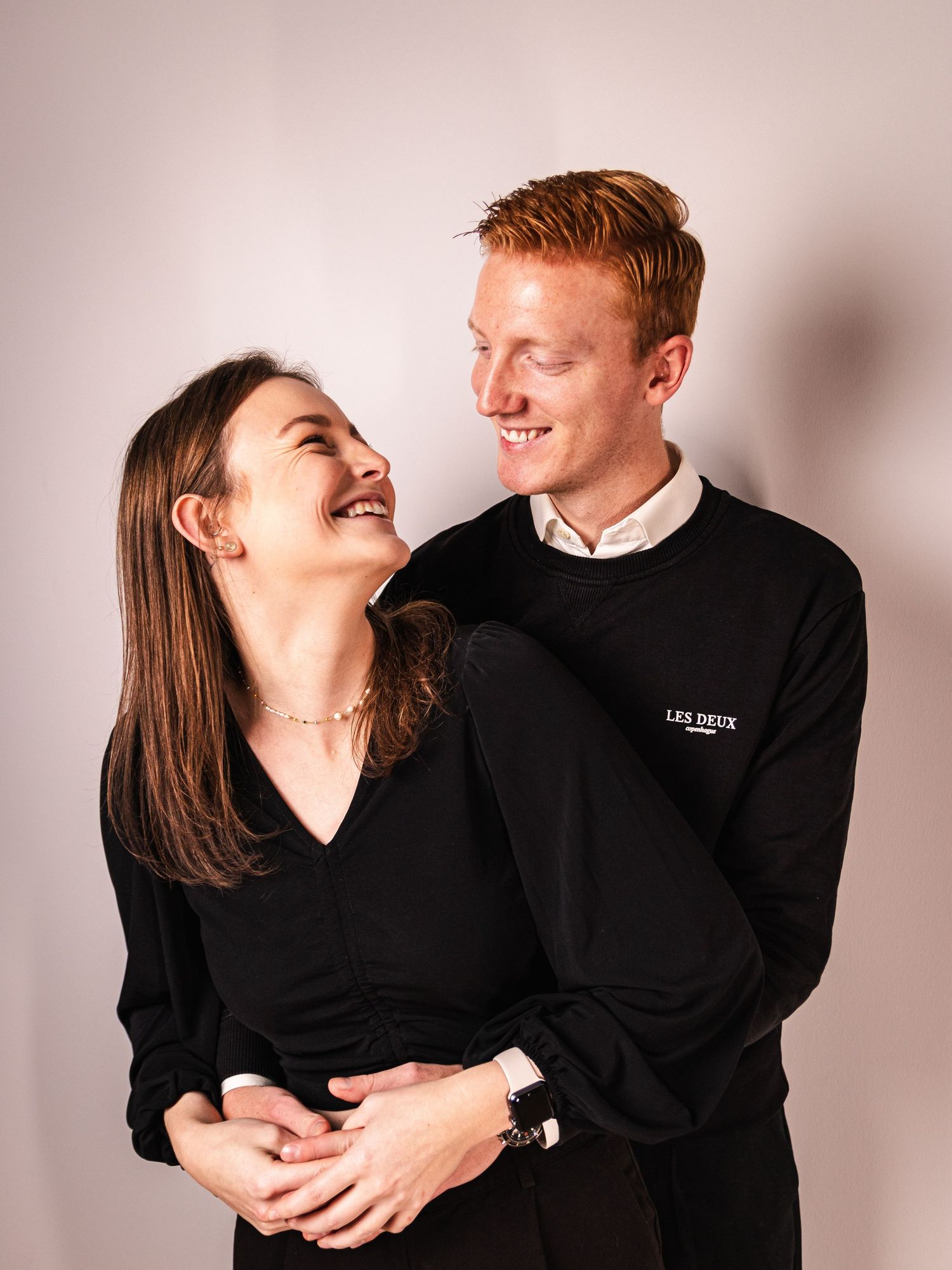Romantic couple in matching black sweaters sharing a joyful moment together.