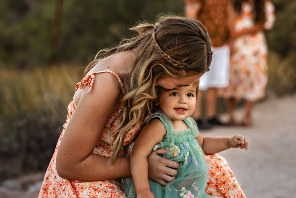 Intimate moment between sister's floral dress outdoors in Scottsdale Arizona