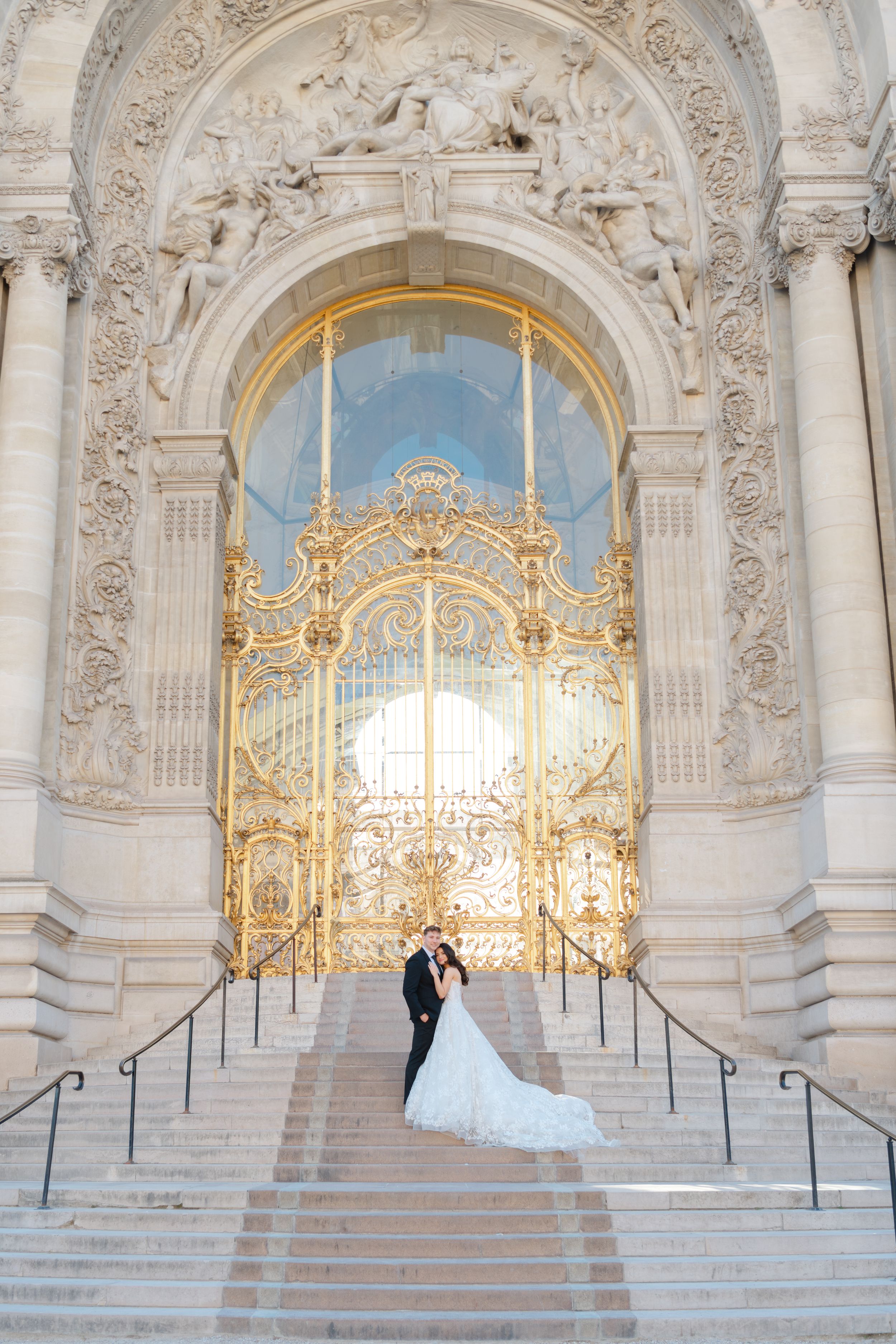 Ornate golden gates and baroque architecture frame the grand entrance of the Petit Palais in Paris on a sunny day.