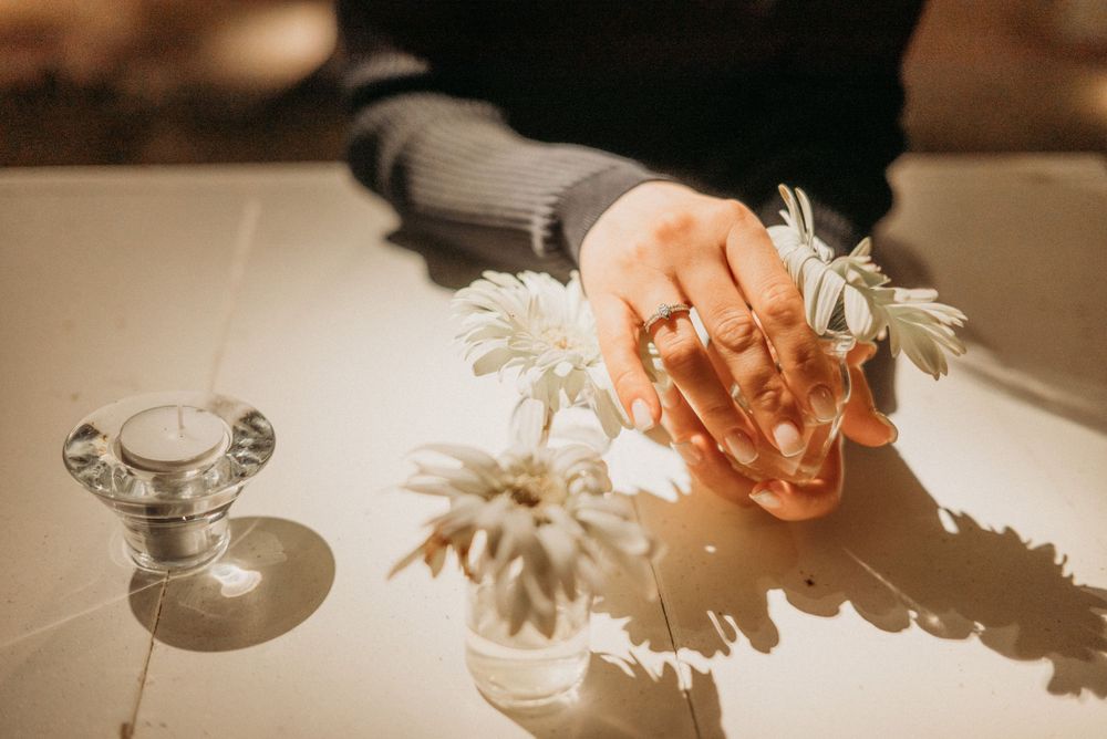 Elegant table setting with delicate flowers casting shadows in warm lighting.