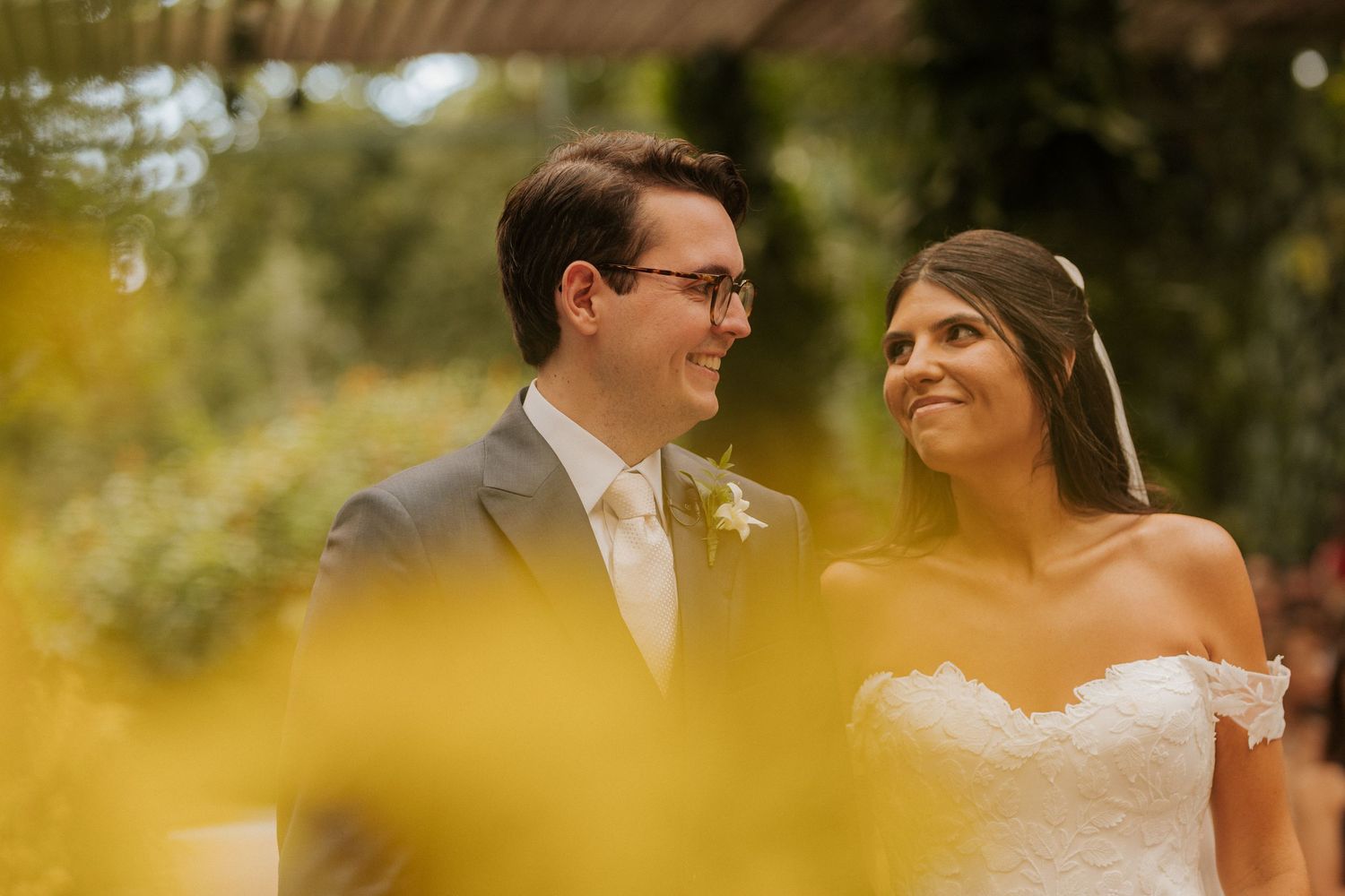Romantic outdoor wedding photography session with natural sunlight filtering through trees.
