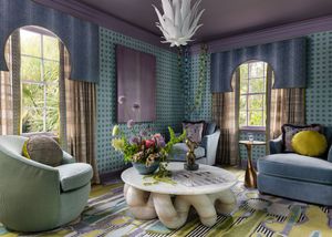 Luxurious living room with teal wallpaper, arched windows, round marble coffee table, and modern velvet seating.