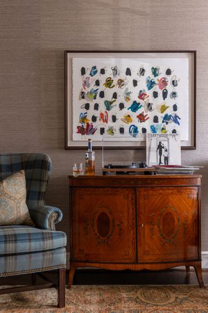 A series of four photos showing an elegant wooden sideboard with inlay details beneath framed artwork in a formal room setting.