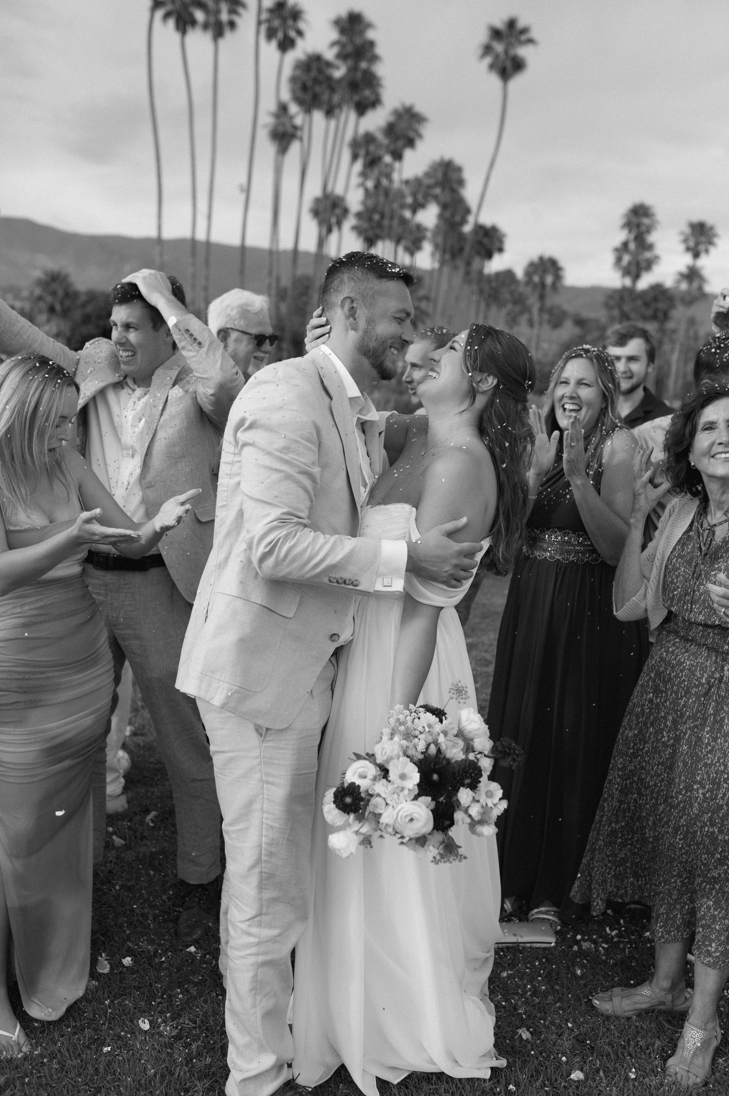 Palm tree-lined outdoor wedding ceremony against a cloudy sky.