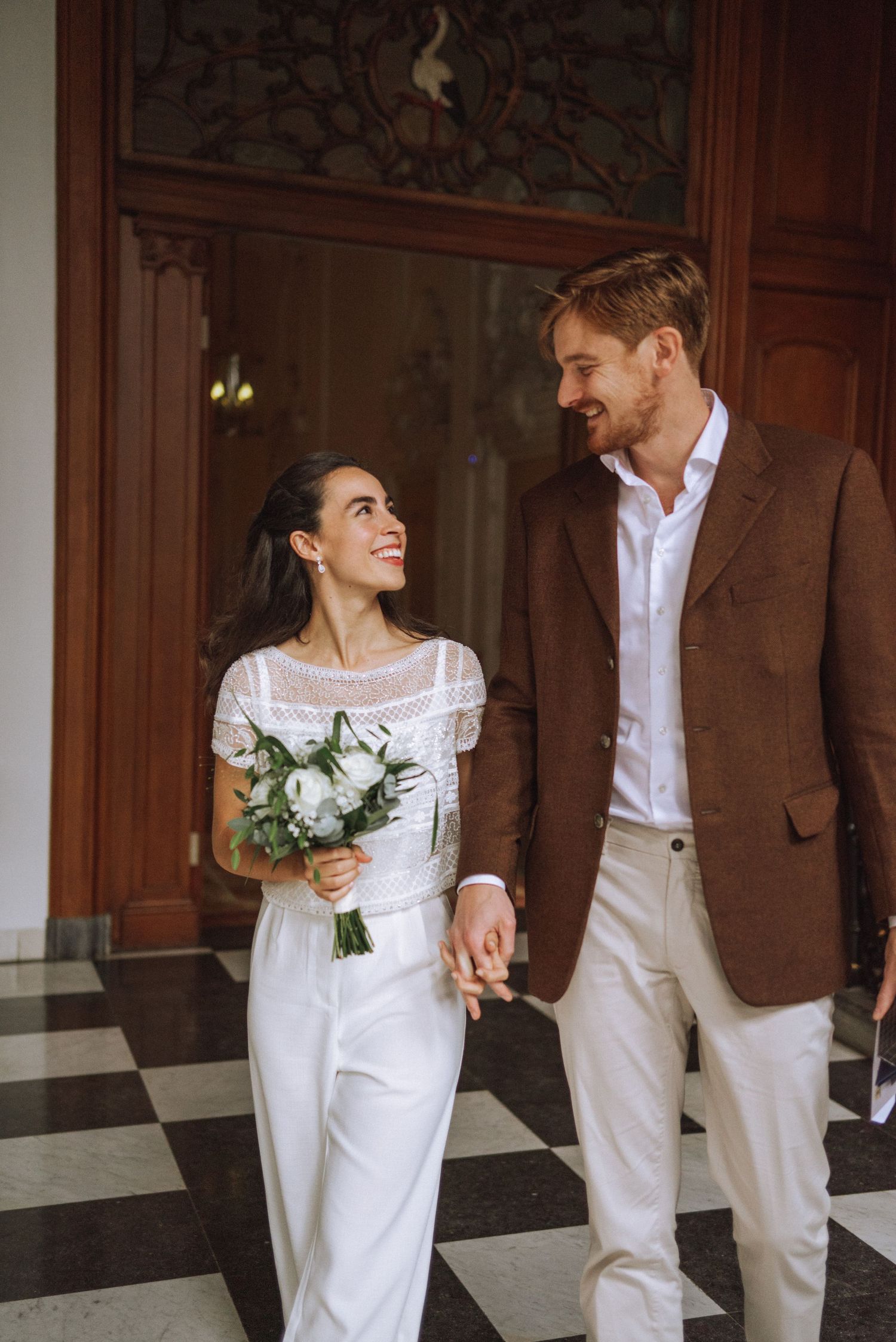 Wedding photoshoot in the Netherlands – a couple walking out of their ceremony, smiling and happy. A true candid moment.