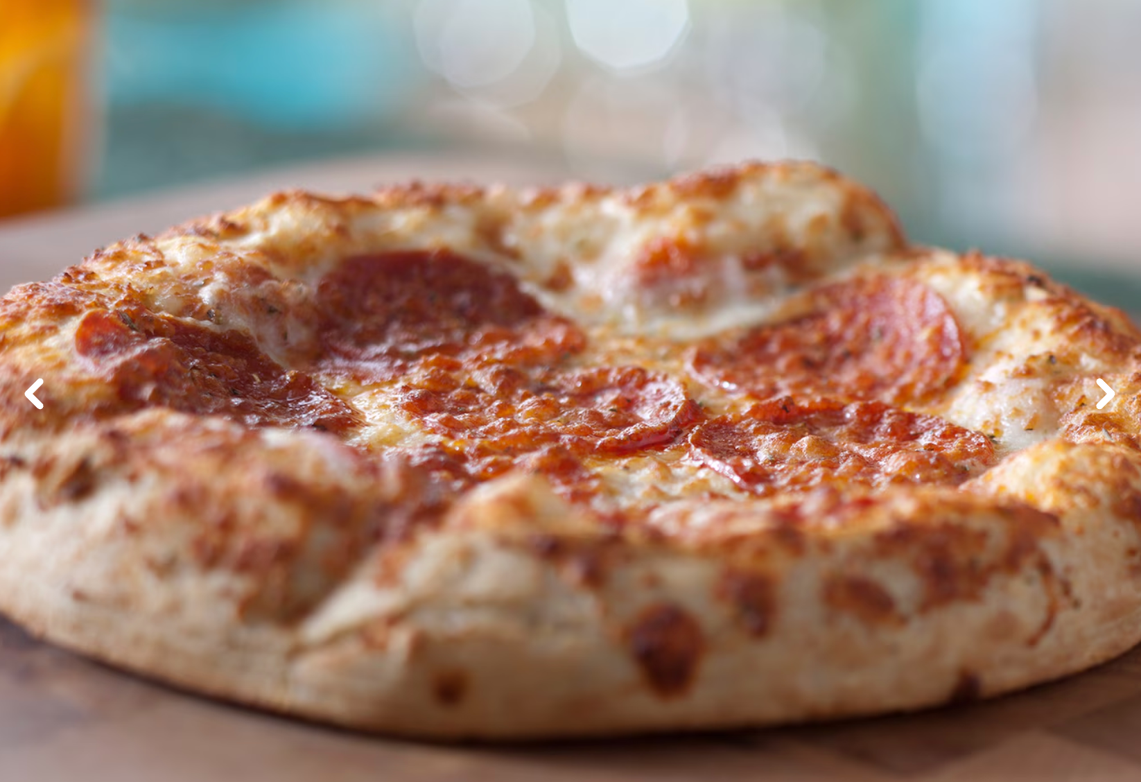 Close-up shot of a freshly baked pizza crust with melted cheese and tomato sauce.
