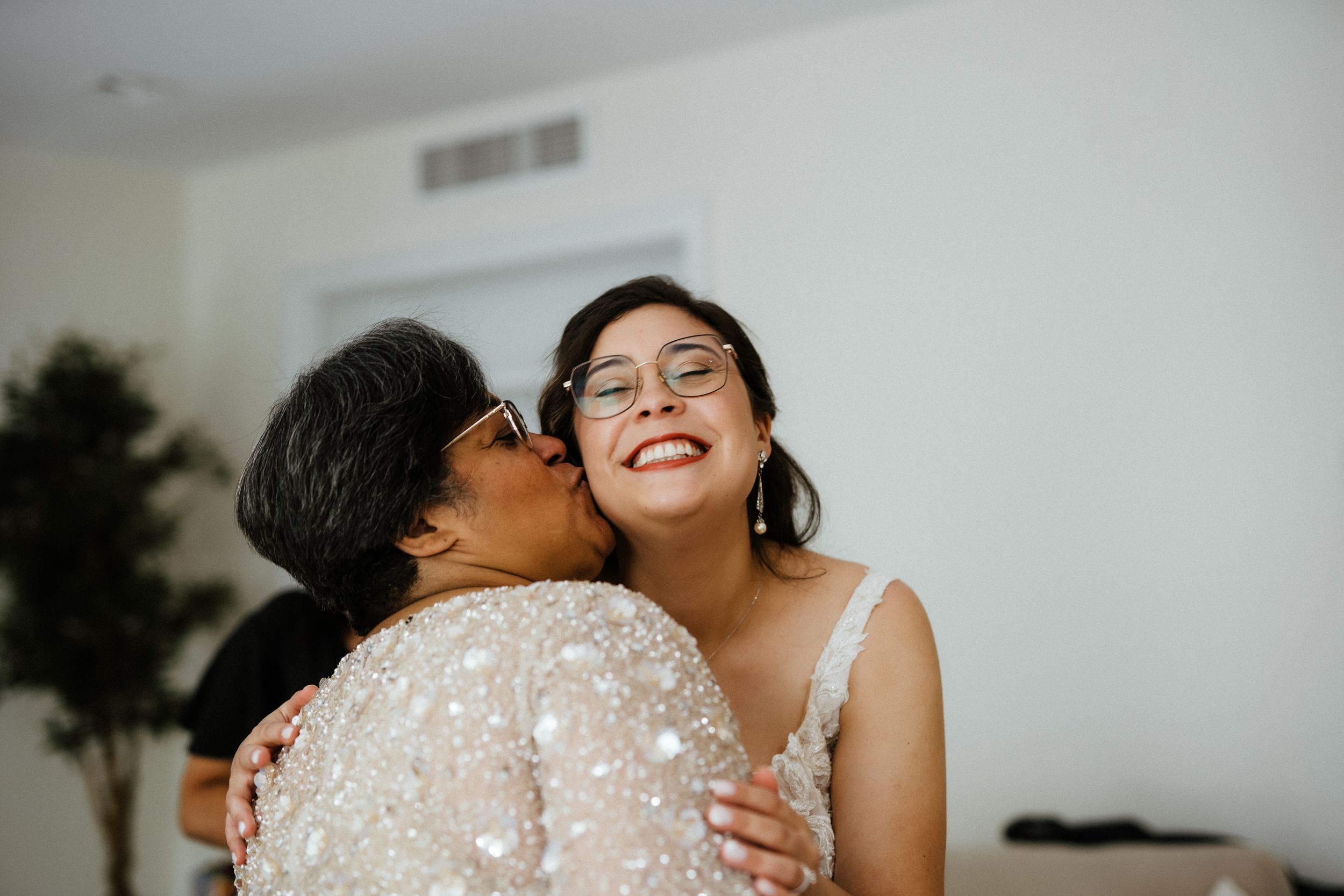 Two people share a joyful intimate moment together while wearing elegant formal attire.