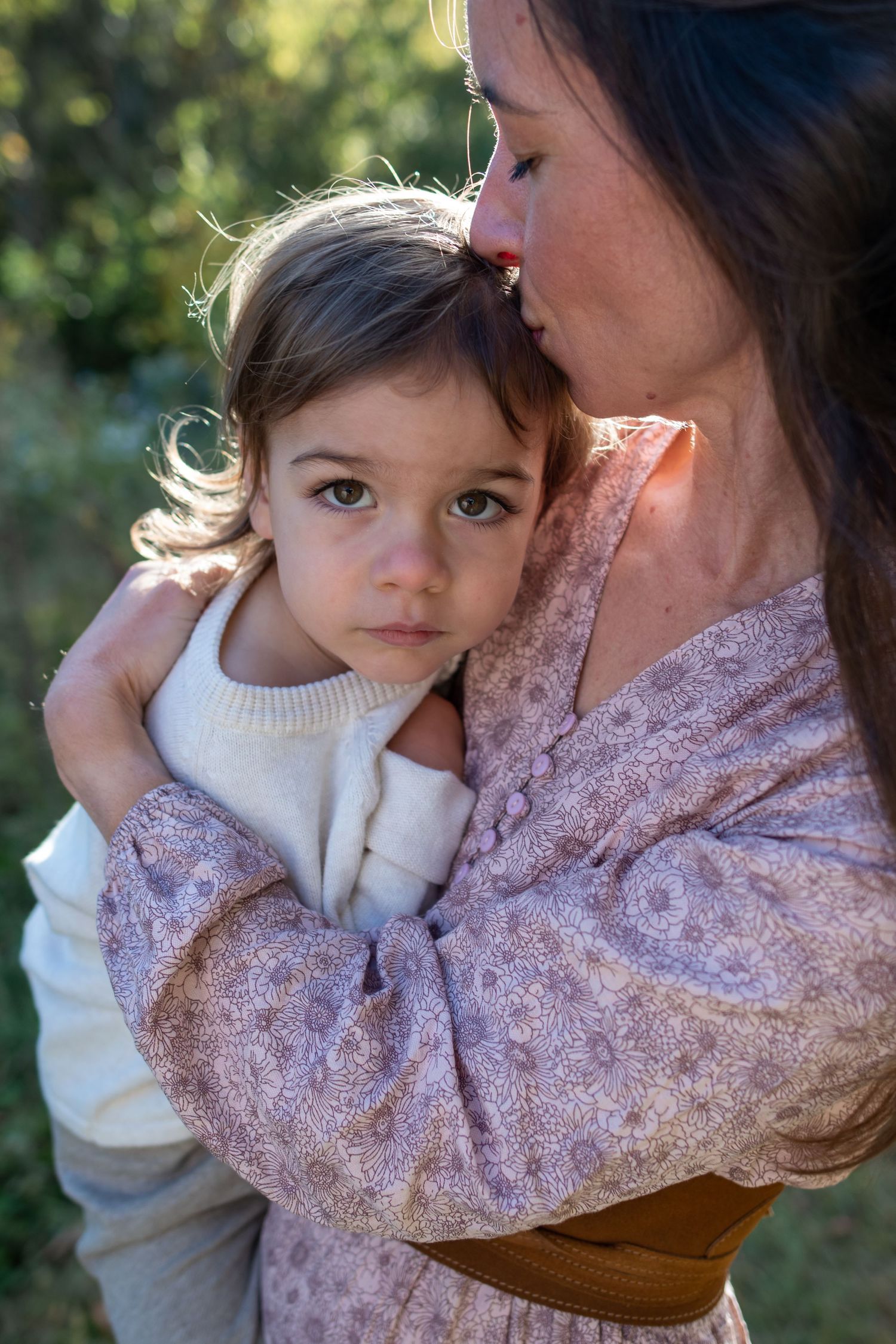A tender moment between parent and child in soft lighting with autumn colors in the background.