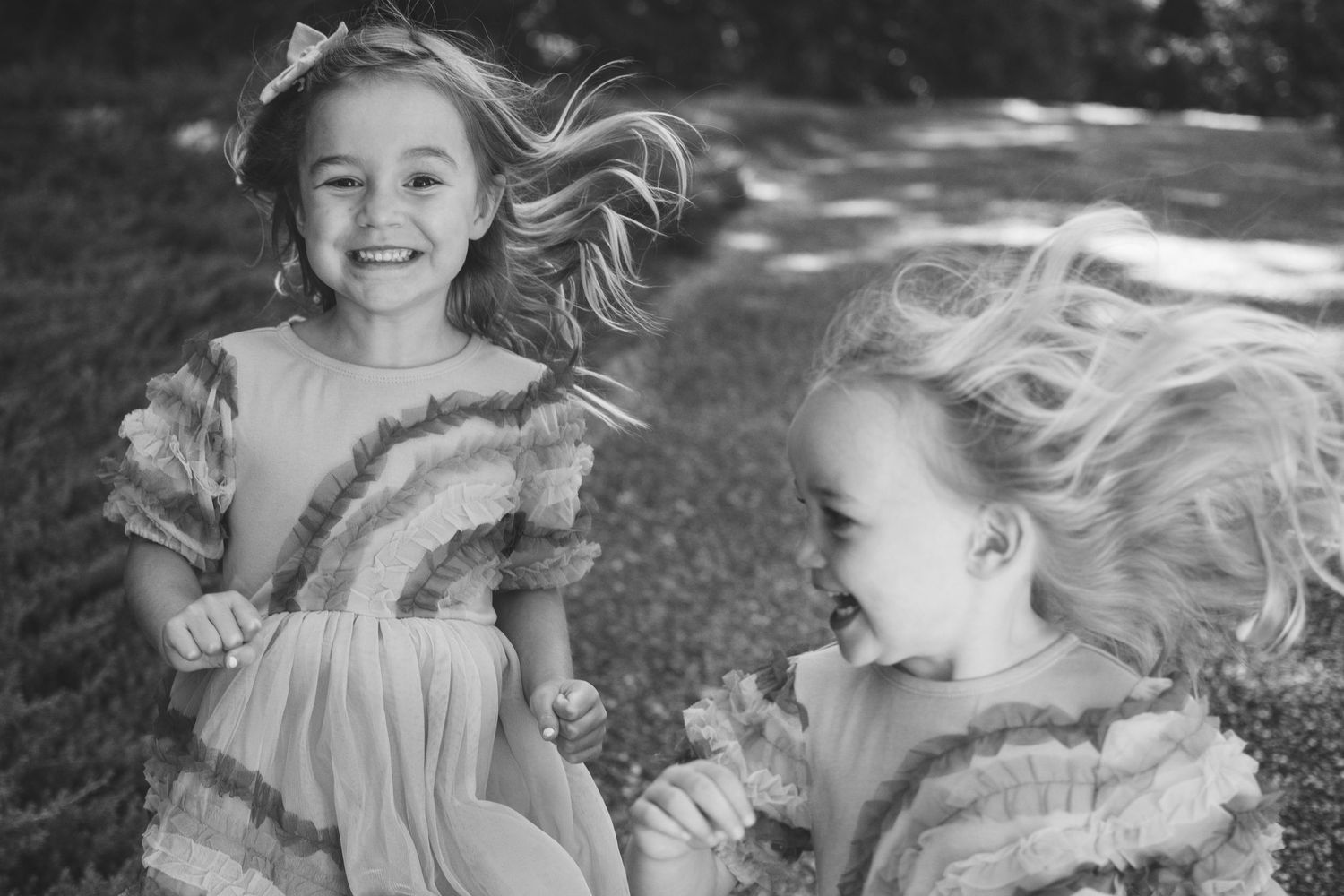 A series of black and white portraits showing a child with flowing hair running and playing outdoors.