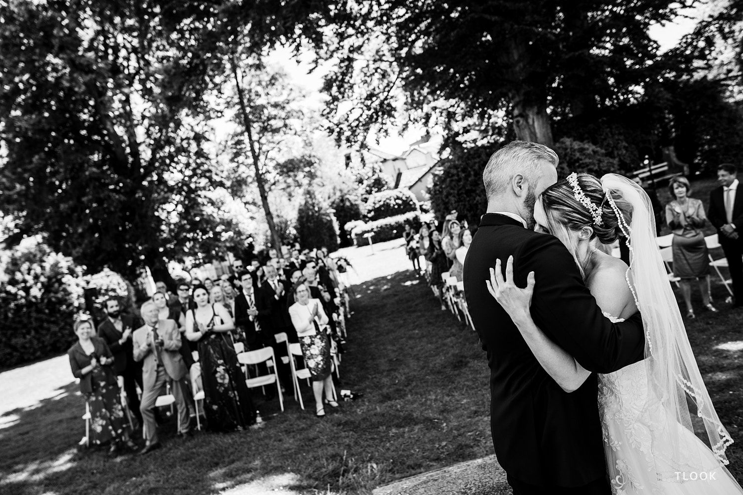 TLOOK photographe de mariage de style documentaire, château de la sarraz fin de la cérémonie les mariés s'enlacent avec les invités