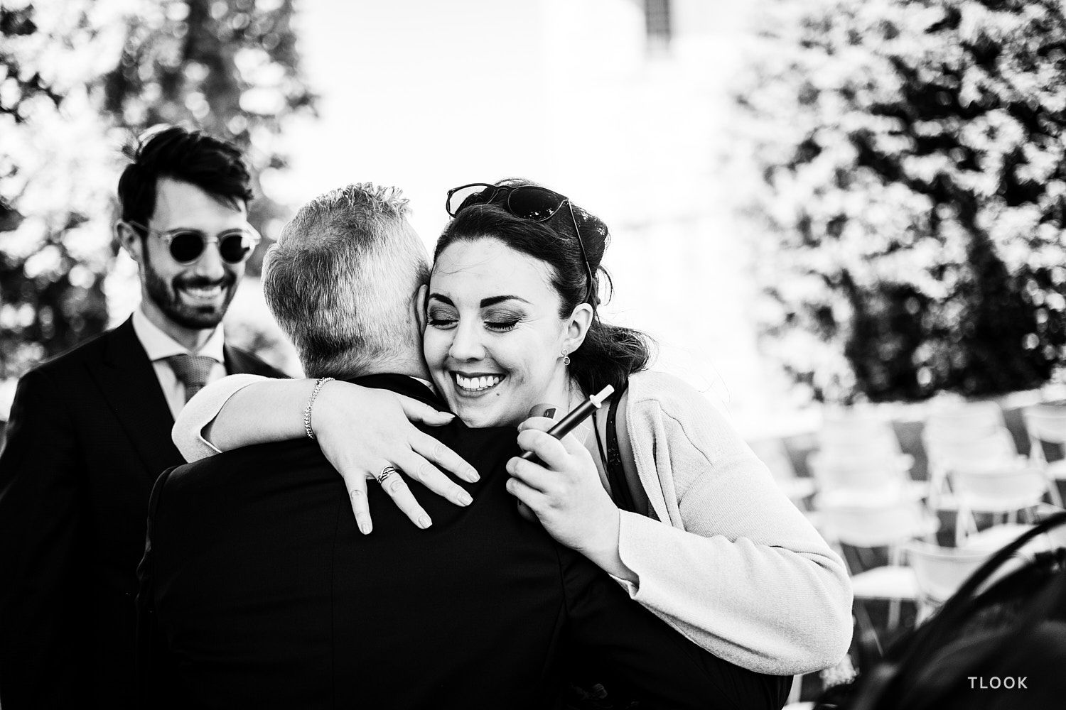 TLOOK photographe de mariage de style documentaire, château de la sarraz une amie enlace le marié