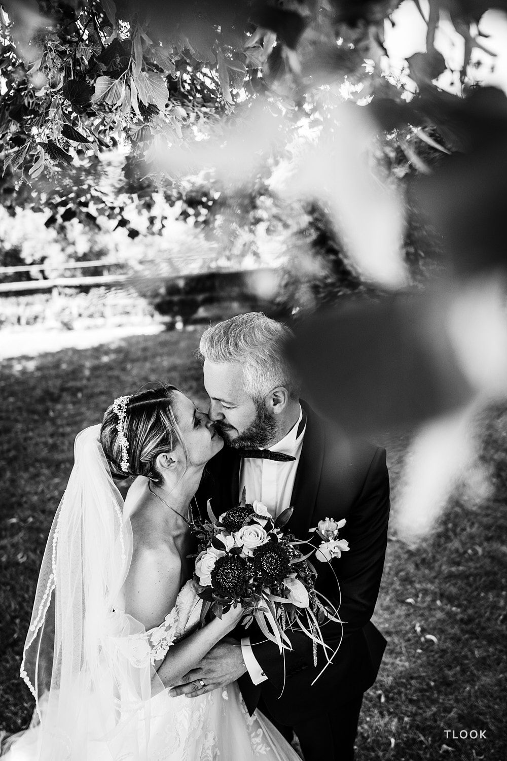 TLOOK photographe de mariage de style documentaire, château de la sarraz mariés qui s'embrassent dans le parc