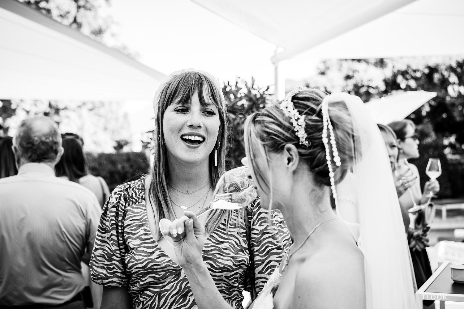 TLOOK photographe de mariage de style documentaire, au grand hôtel du lac cocktail sur la terrasse une invitée discute avec la mariée
