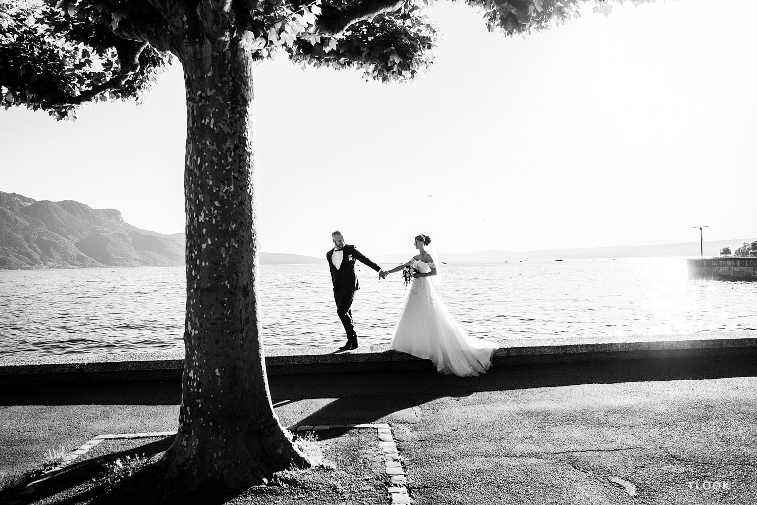 TLOOK photographe de mariage de style documentaire, portrait des mariés au grand hôtel du lac en se tenant par la main au bord du lac léman