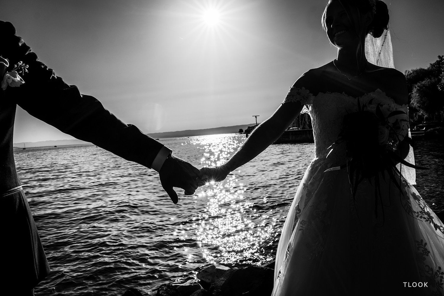TLOOK photographe de mariage de style documentaire, portrait des mariés au grand hôtel du lac en se tenant par la main au bord du lac léman