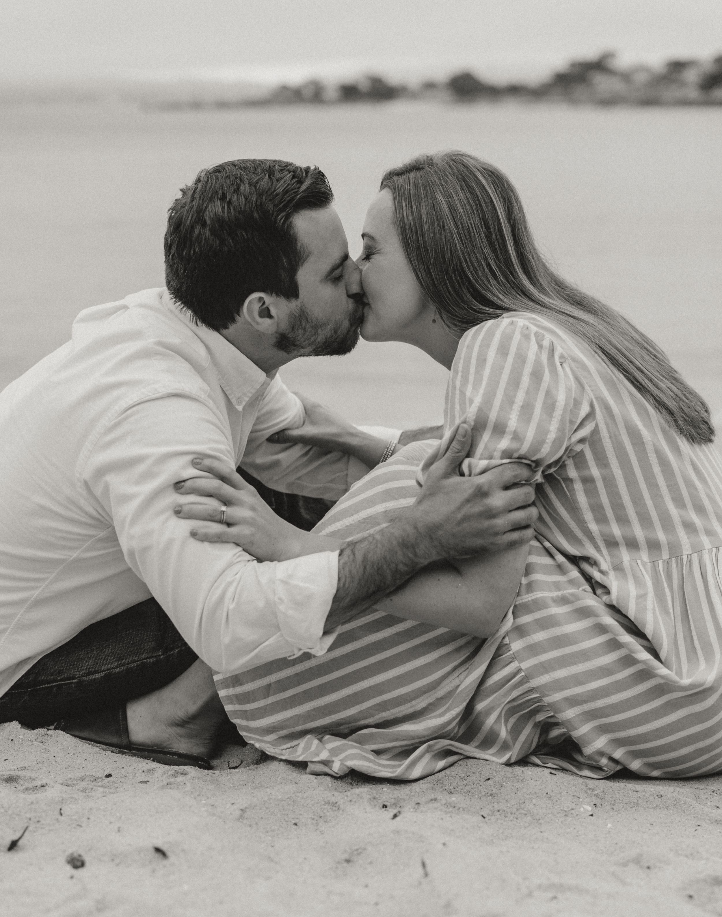 Black and white series of photos showing a romantic couple lying on the beach while sharing an intimate moment.