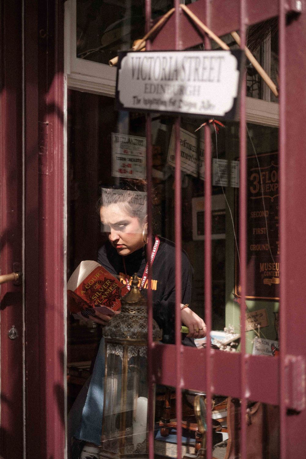 Worker in an apron seen through a shop window frame.