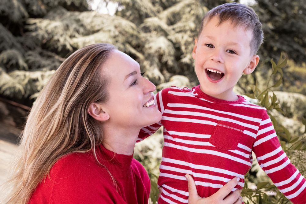 Joyful candid moment shared between parent and child in matching red outfits.
