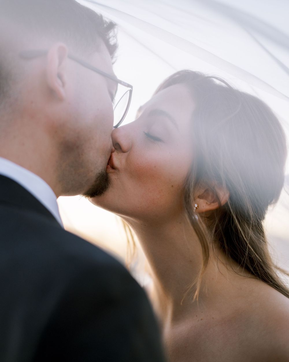 A tender wedding moment captured in close-up during sunset with soft natural lighting.