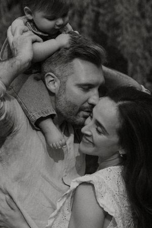 Black and white romantic engagement photos show a couple sharing tender moments laughing and embracing together.