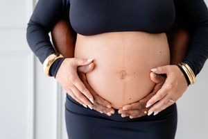 A series of four belly photos showing a pregnant woman's growing baby bump during pregnancy progression.