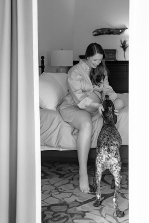 A playful cat stands on hind legs reaching up towards someone sitting on a couch in a series of black and white images.