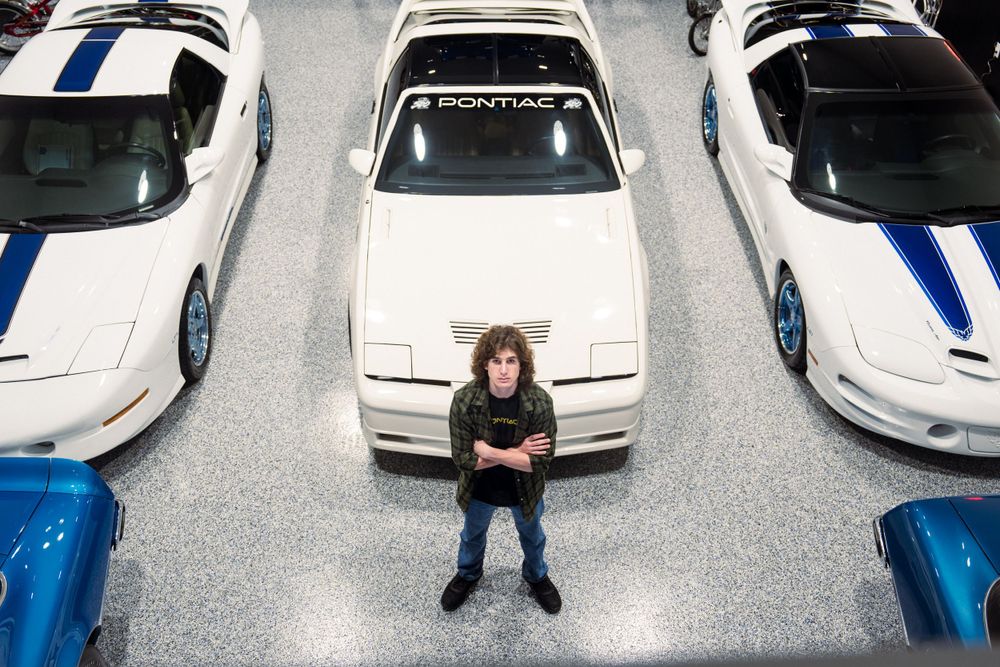 Overhead view of person standing between three classic Pontiac cars.