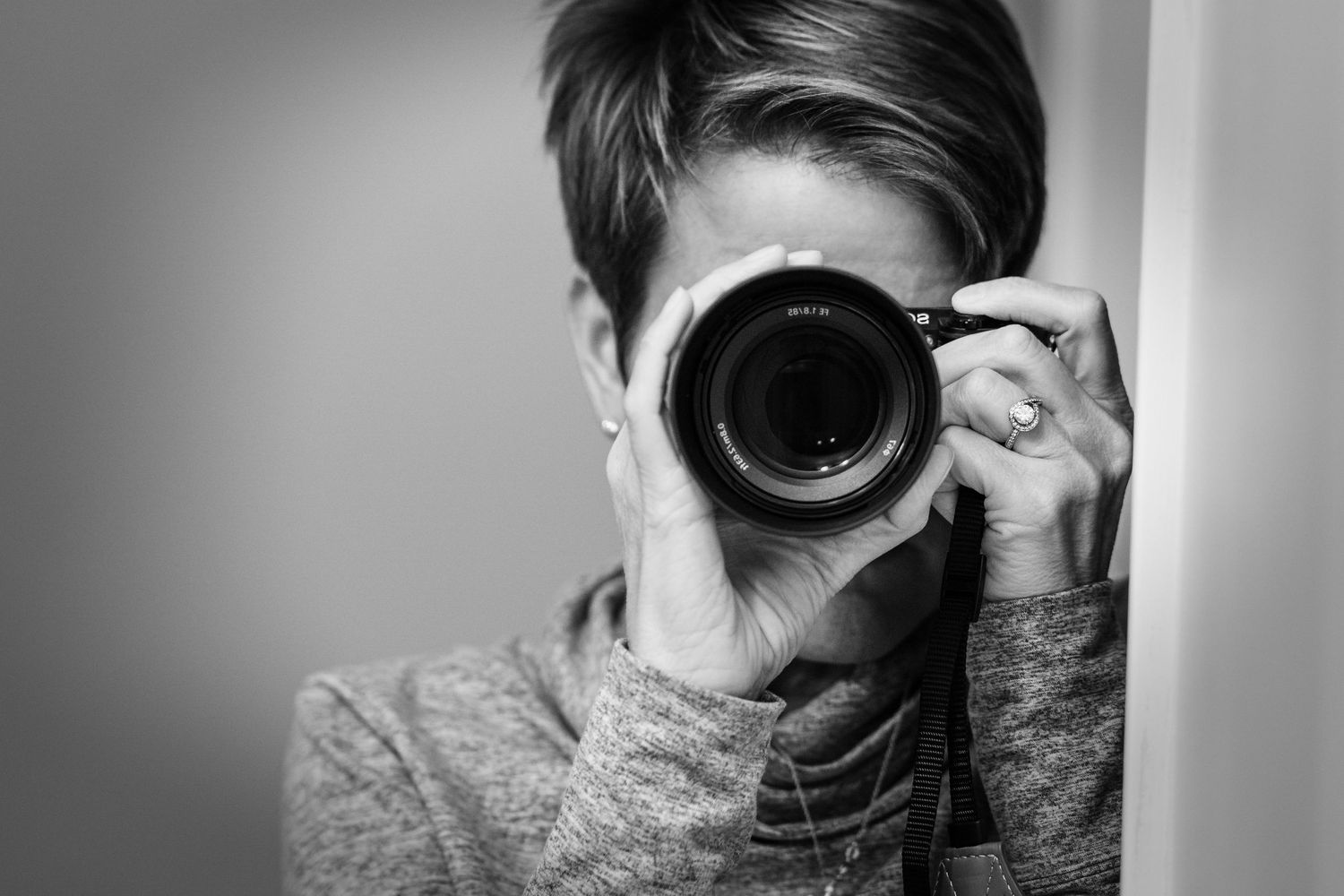 Black and white photo of a woman holding a camera taken by a photographer in Dandridge, Tennessee