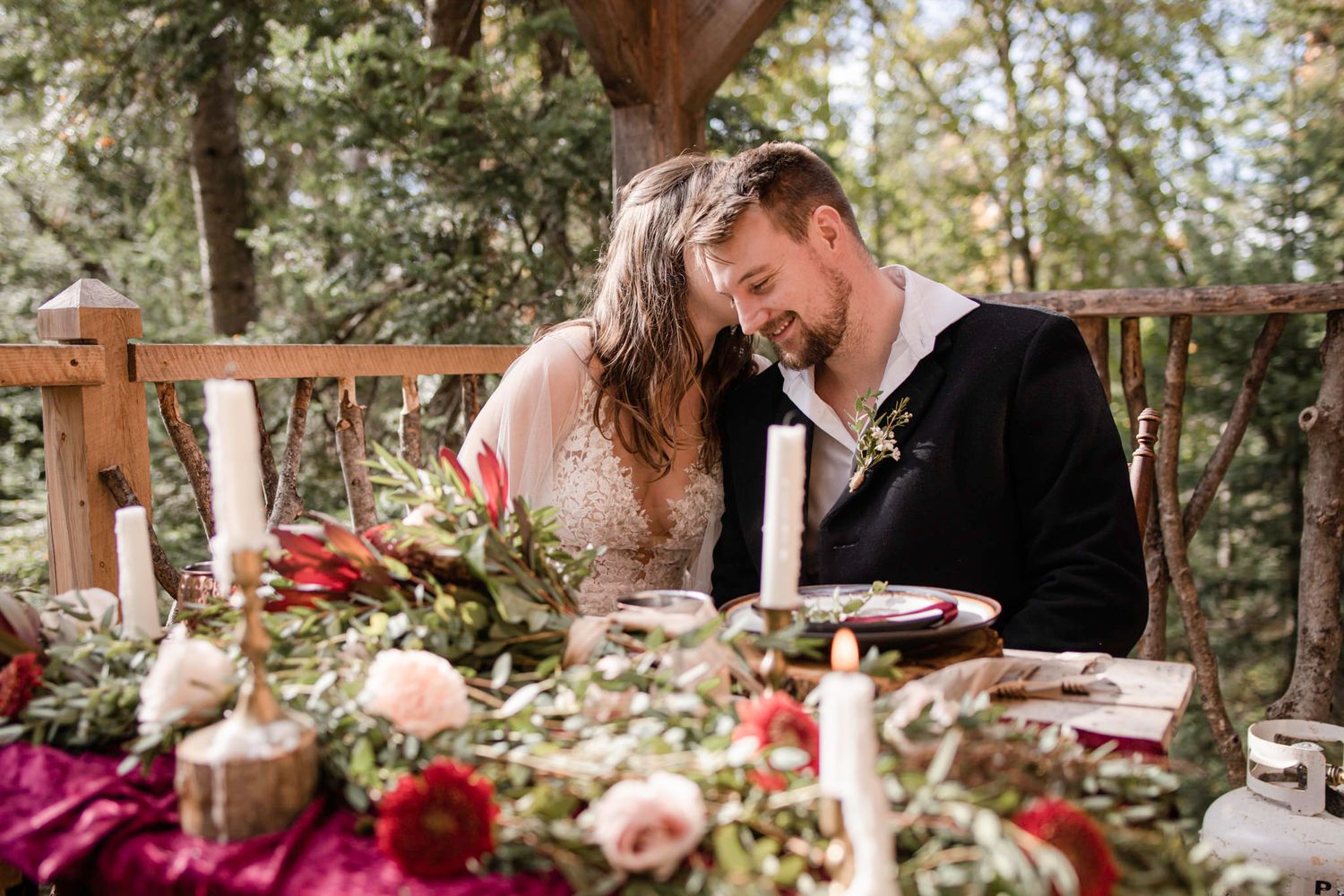 Eloping couple sharing a laugh as they sit at a decorated table on the balcony in Mont Tremblant, Quebec, Canada.
