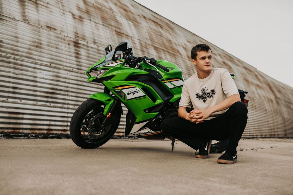 senior boy poses with his motorcycle