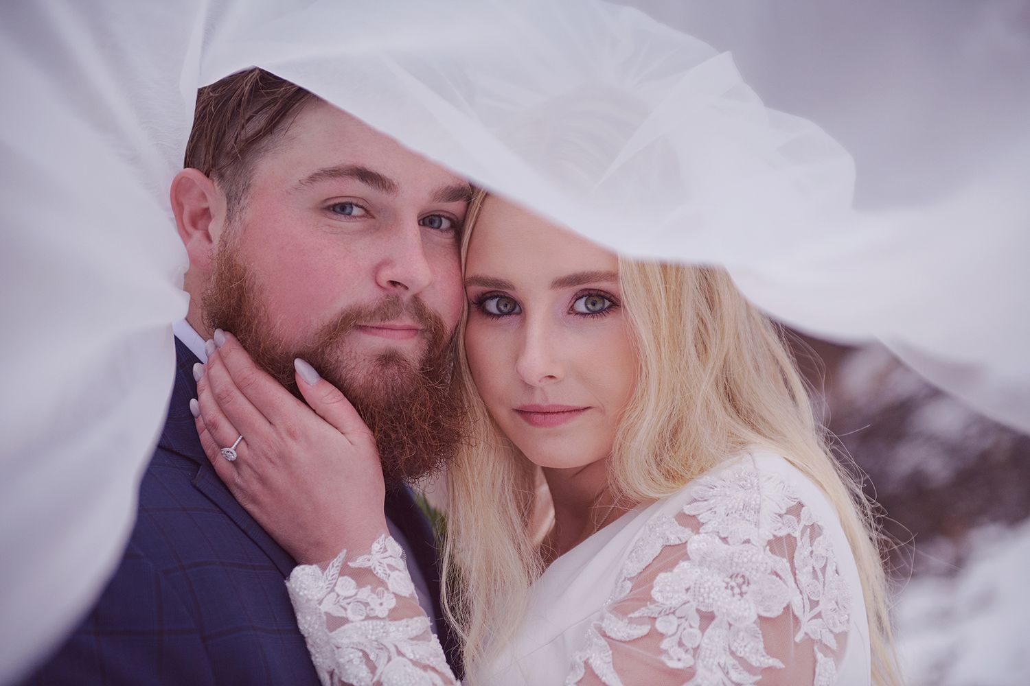 A romantic wedding photo with a couple embracing under the vale, winter backdrop.Blackfoot, Idaho Falls, Pocatello Wedding photographer