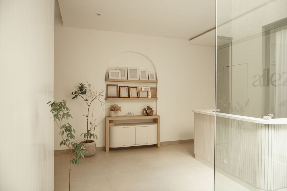 Minimalist interior with wooden shelving unit, plants and glass partition.