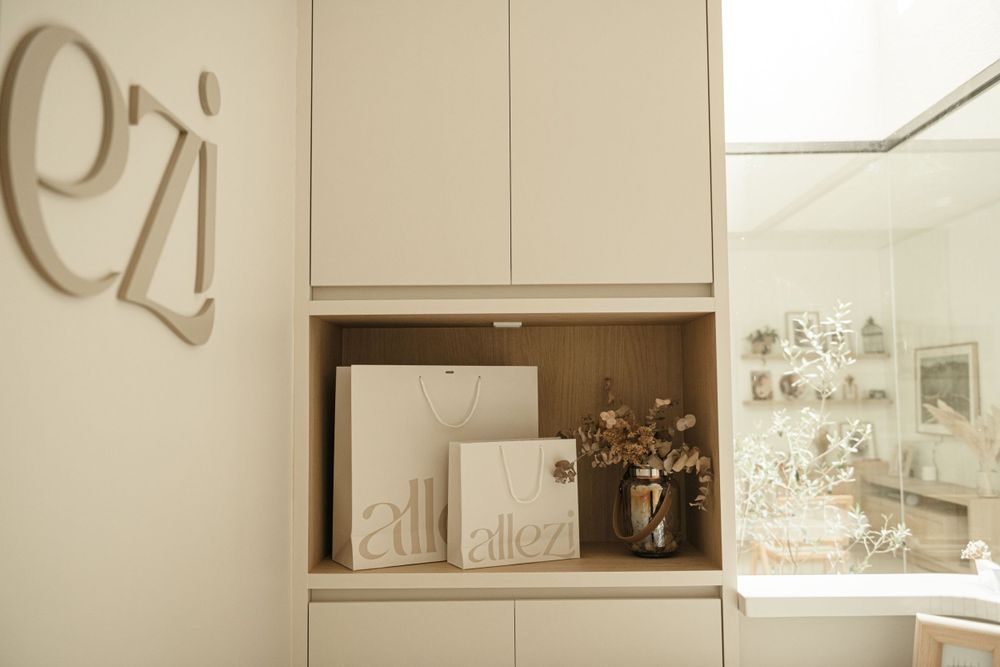 Built-in storage cabinet displaying studio branding materials in neutral tones.