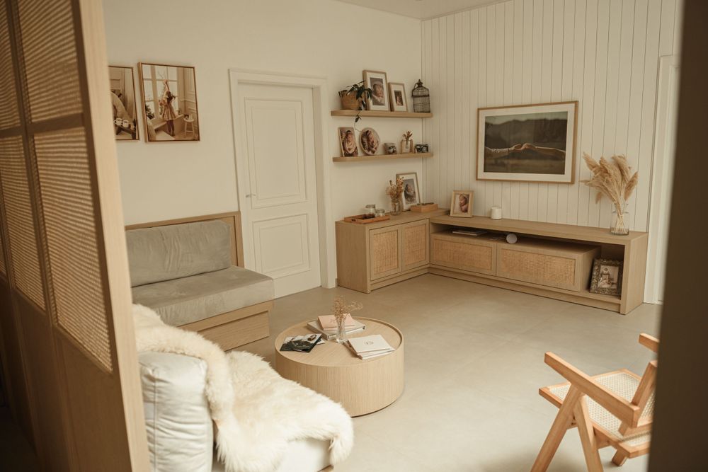 Minimalist interior room with wooden furniture, white walls, and cozy seating area.