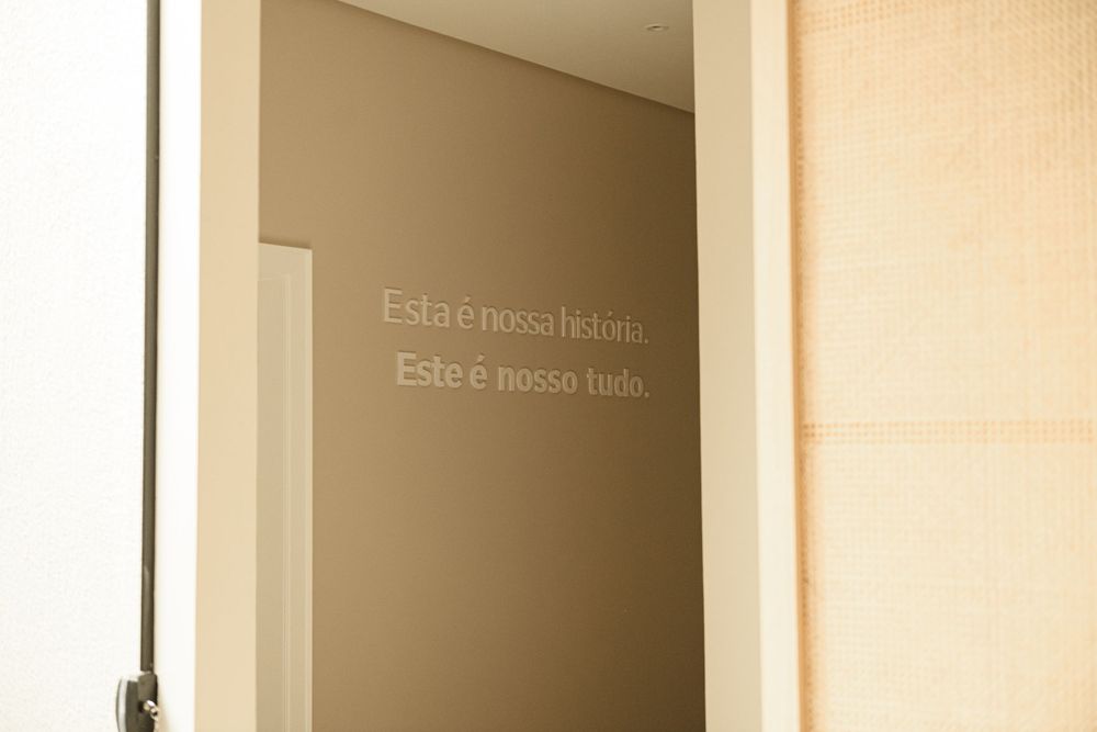 Text written on a beige wall with soft lighting and shadows.