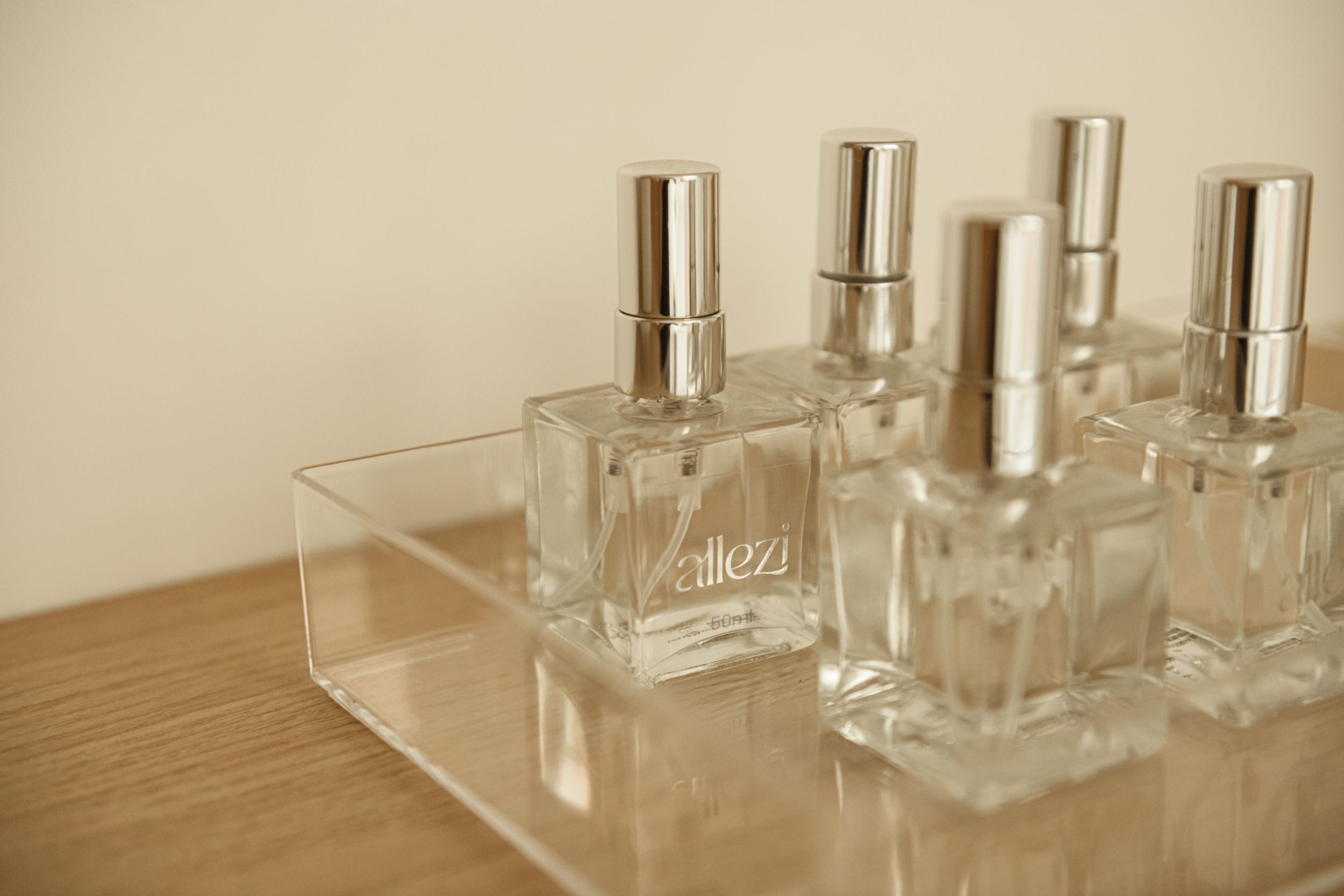 Clear glass perfume bottles arranged neatly on a wooden surface.