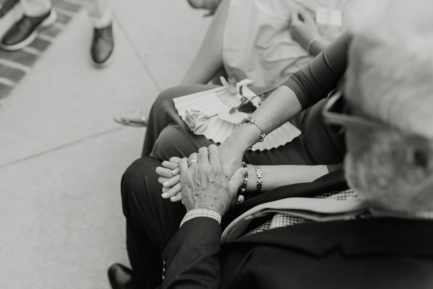 Black and white wedding detail shots showing hands and formal attire.