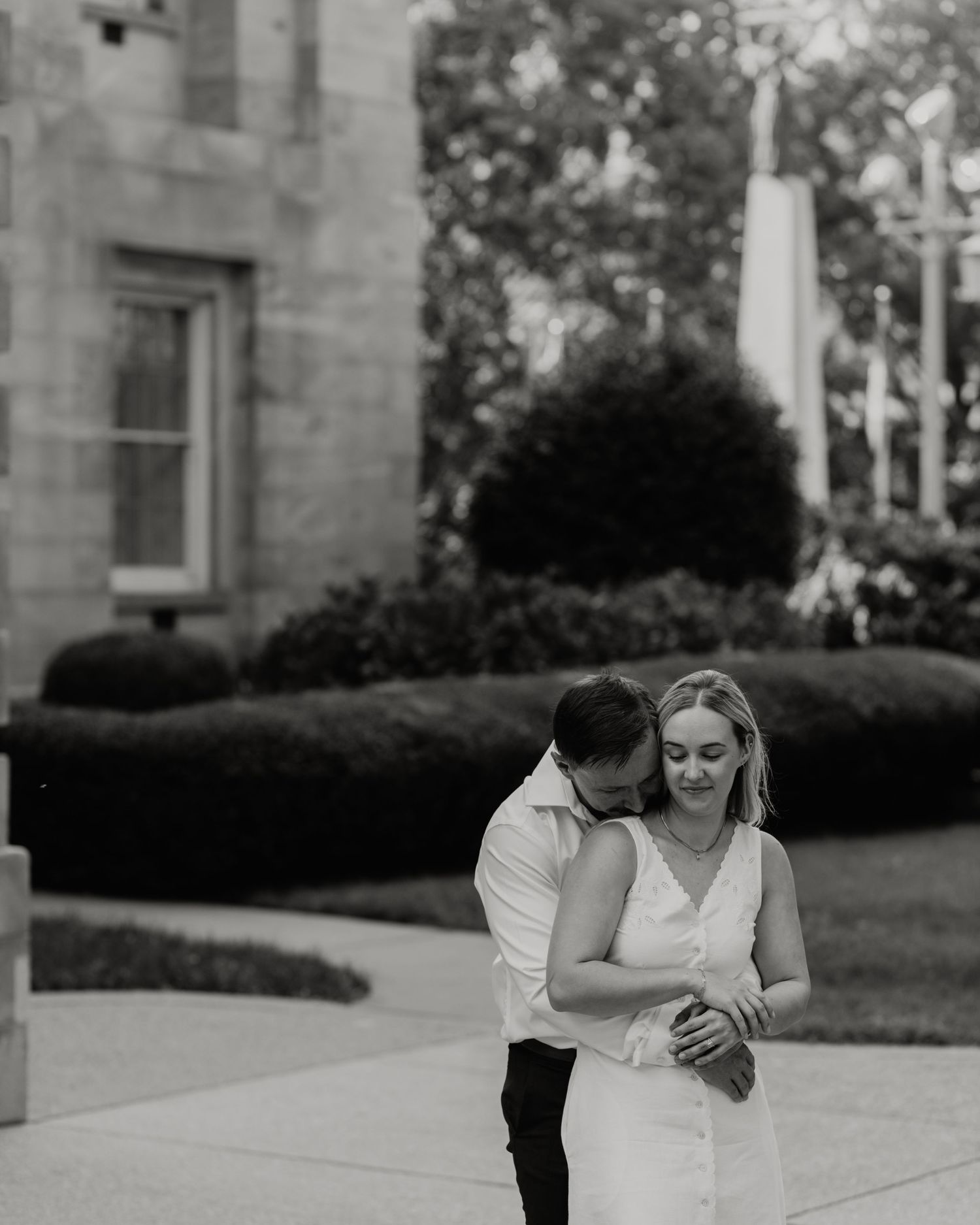 An intimate black and white portrait of a couple on stone steps.