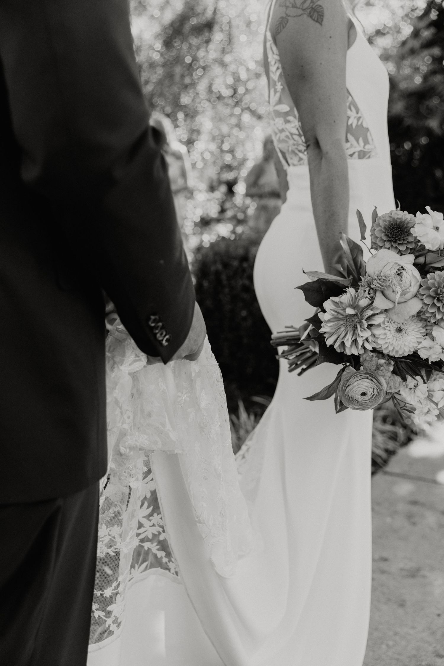 Elegant white wedding dress details with delicate lace trim and floral bouquet.