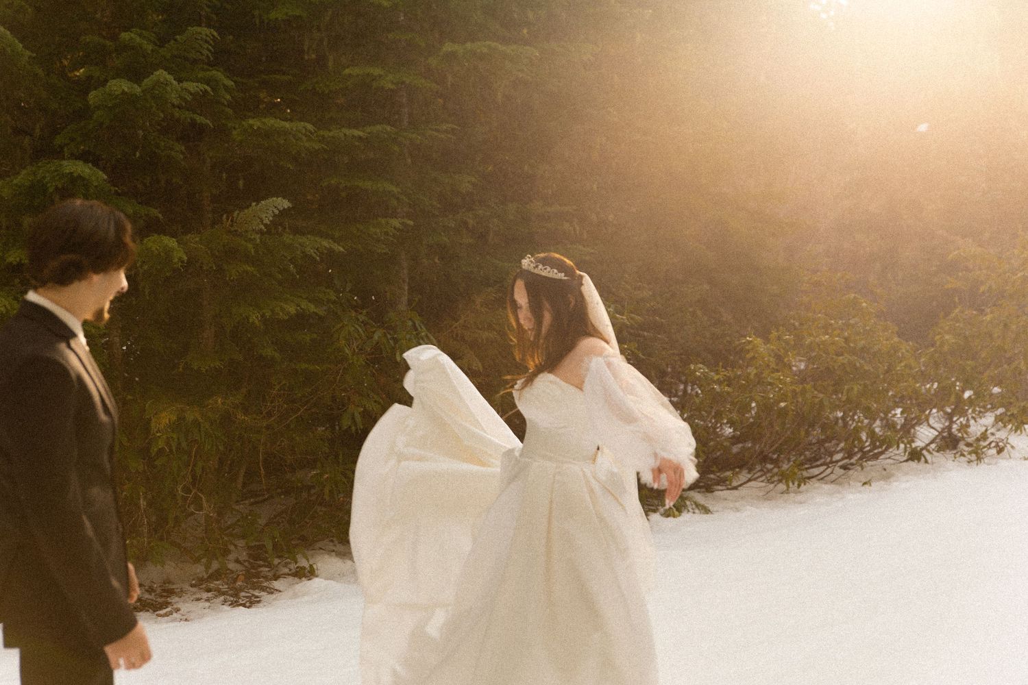 A winter wedding scene with a flowing white dress against snowy backdrop.