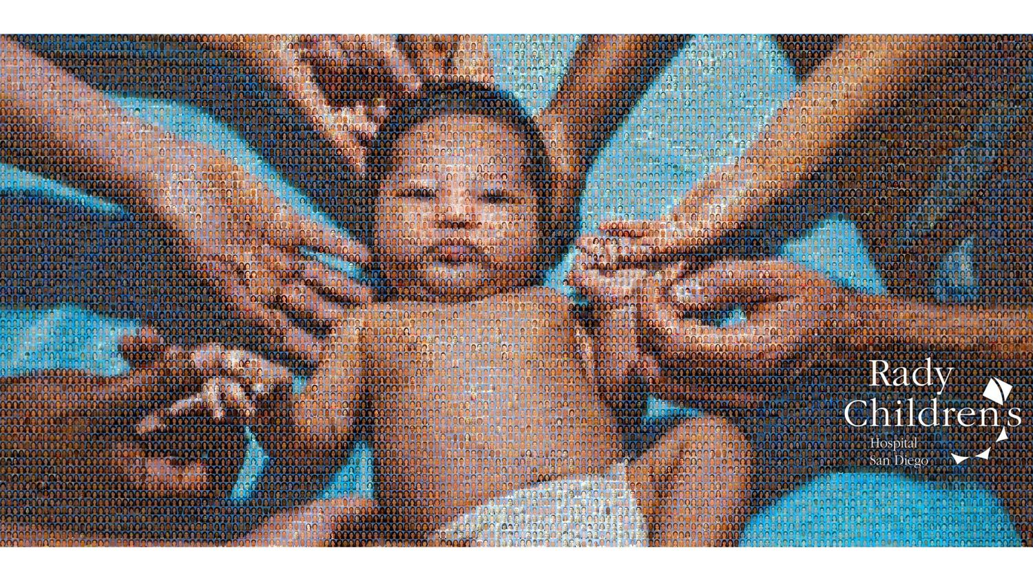 A small baby wearing a diaper is held up by multiple hands reaching from all directions against a blue background.
