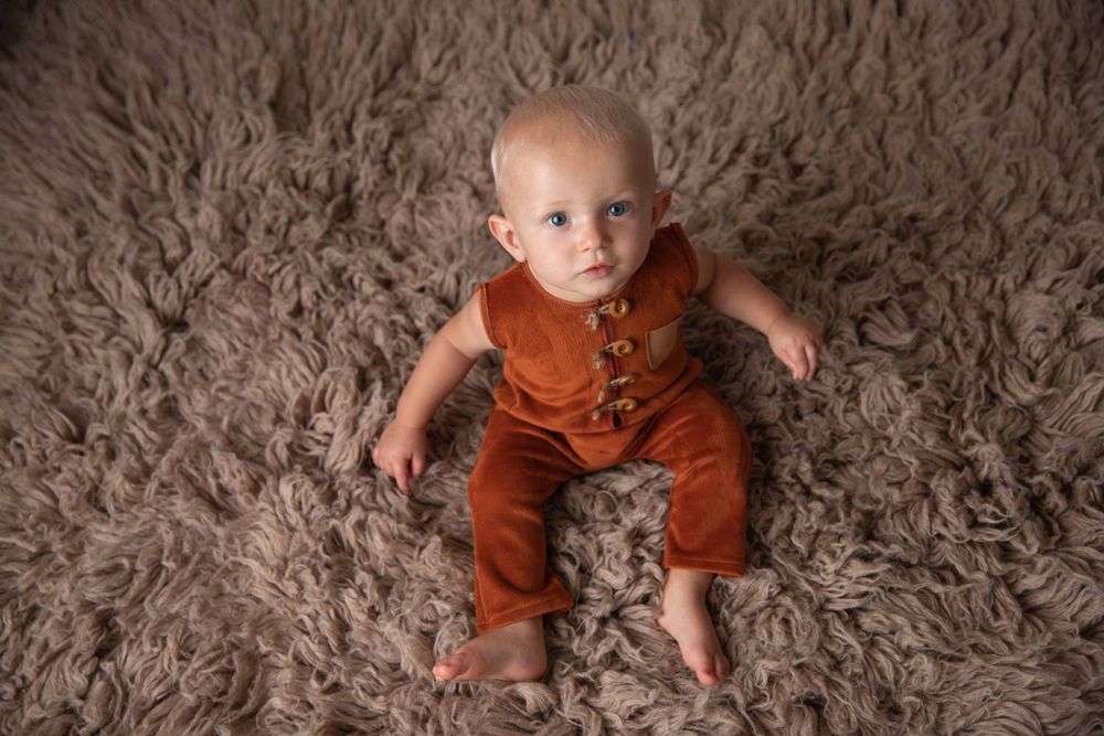 Baby in a rust-colored velvet outfit during milestone photography session in central Florida