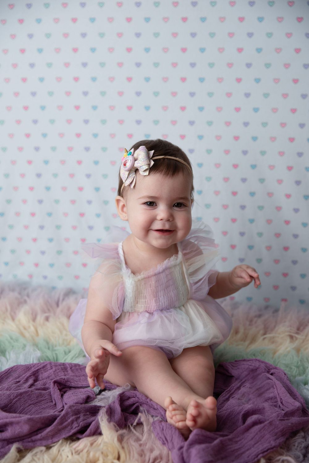 Baby girl in rainbow outfit during milestone photography session in Orange City Florida.