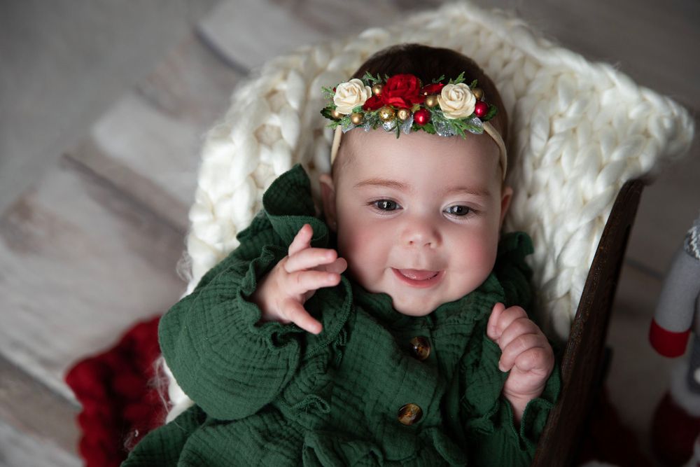 Baby in holiday outfit during Christmas milestone photography session in Orange City Florida.