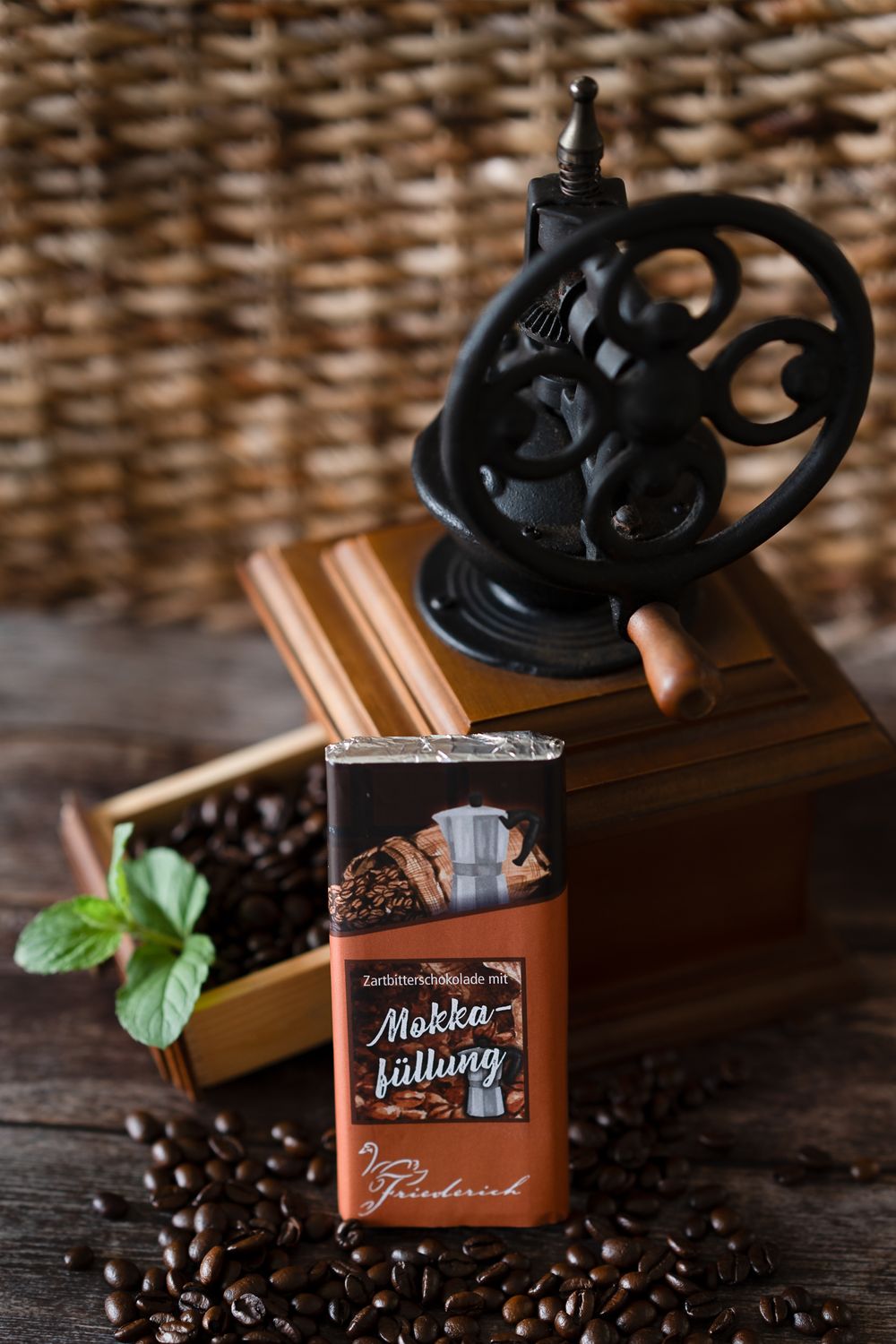 Food Fotografie. Vintage coffee grinder with coffee beans and chocolate bar on rustic wooden surface.
