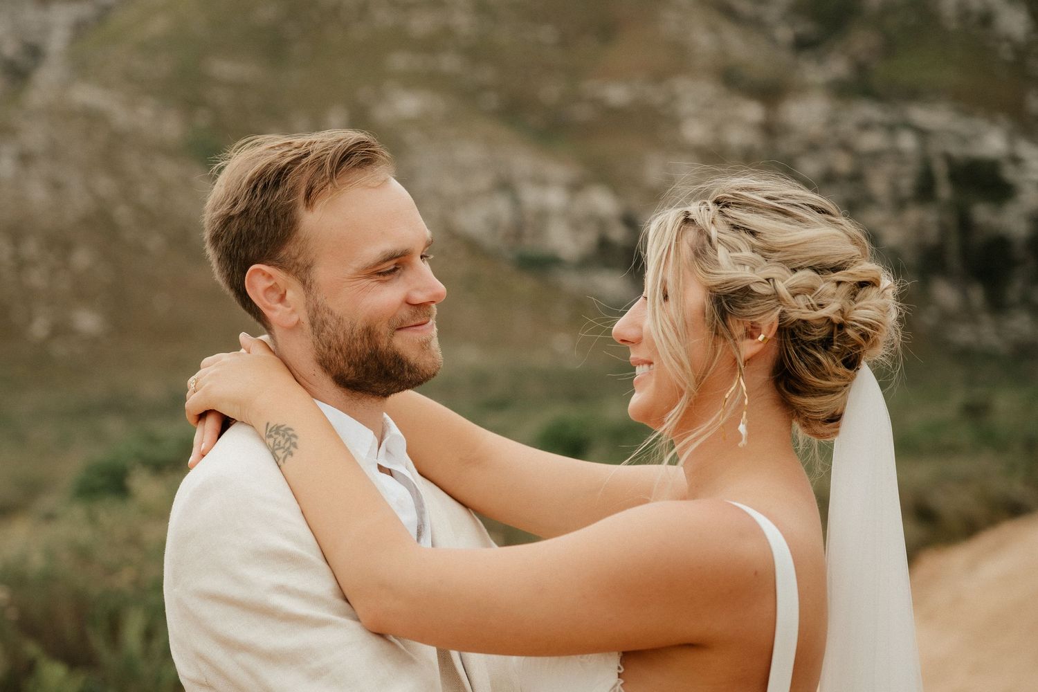 A tender moment between newlyweds against a backdrop of majestic mountains.