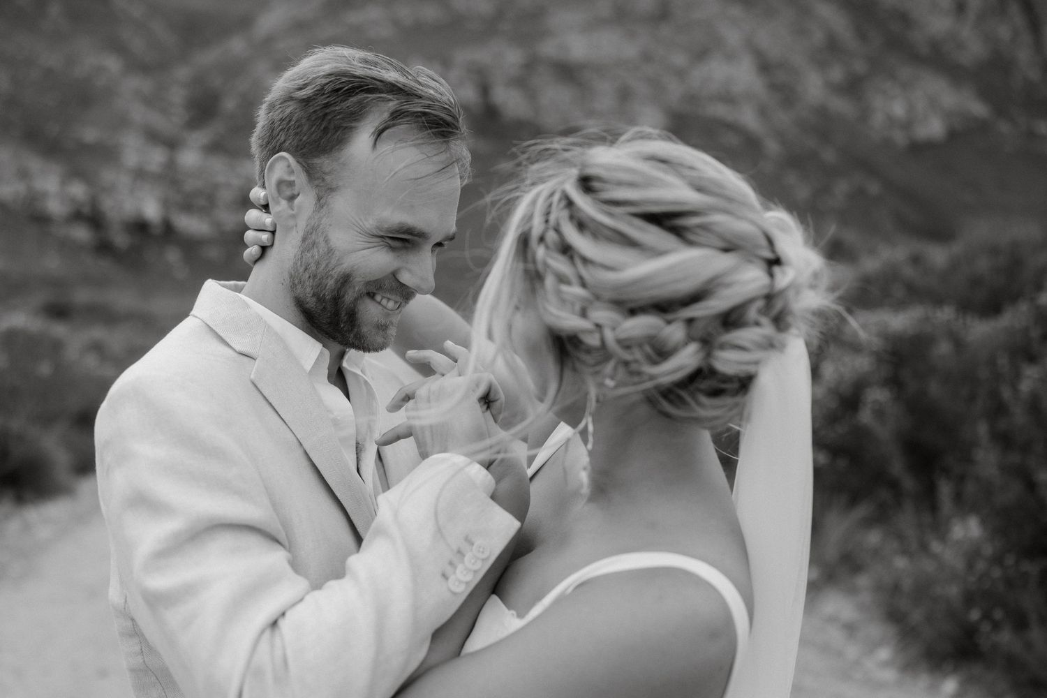 An intimate black and white portrait of newlyweds sharing a tender moment.